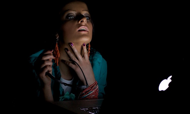 woman_in_a_dark_room_looking_to_a_mac_computer