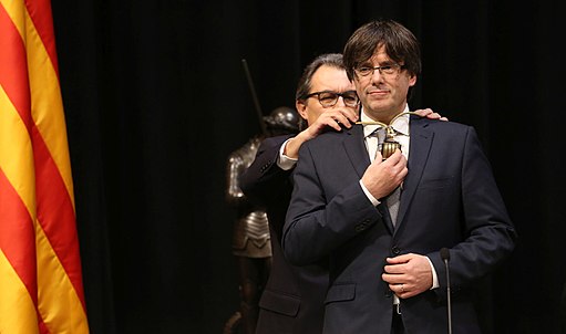 Puigdemont assuming the position of President, in front of his predecessor Artur Mas. (Creative Commons)