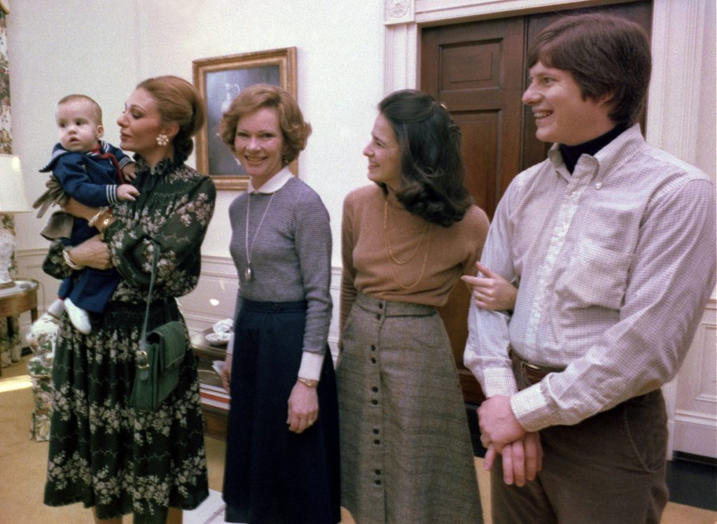 Above: The Shahbanou of Iran holds Jimmy Carter IV while Rosalynn Carter, Caron Carter and Chip Carter watch at the White House, January 1978, photo: Schumacher, Karl, Public domain, via Wikimedia Commons